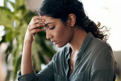 Person resting their temples during headache assessment at Merivale Clinic in Ottawa
