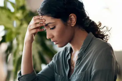 Person resting their temples during headache assessment at Merivale Clinic in Ottawa