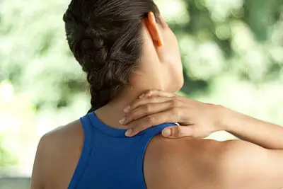 Person holding the side of their neck during assessment at Merivale Clinic in Ottawa