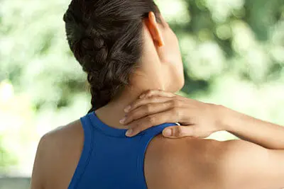 Person holding the side of their neck during assessment at Merivale Clinic in Ottawa